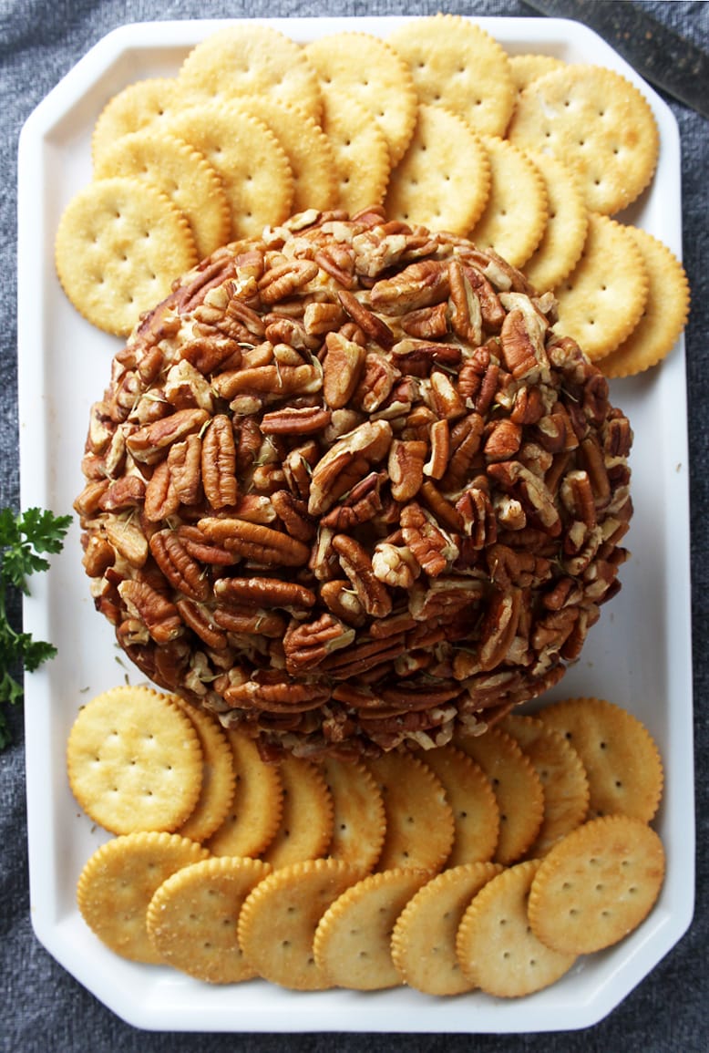 overhead picture of vegan cheese ball on a platter with crackers. 