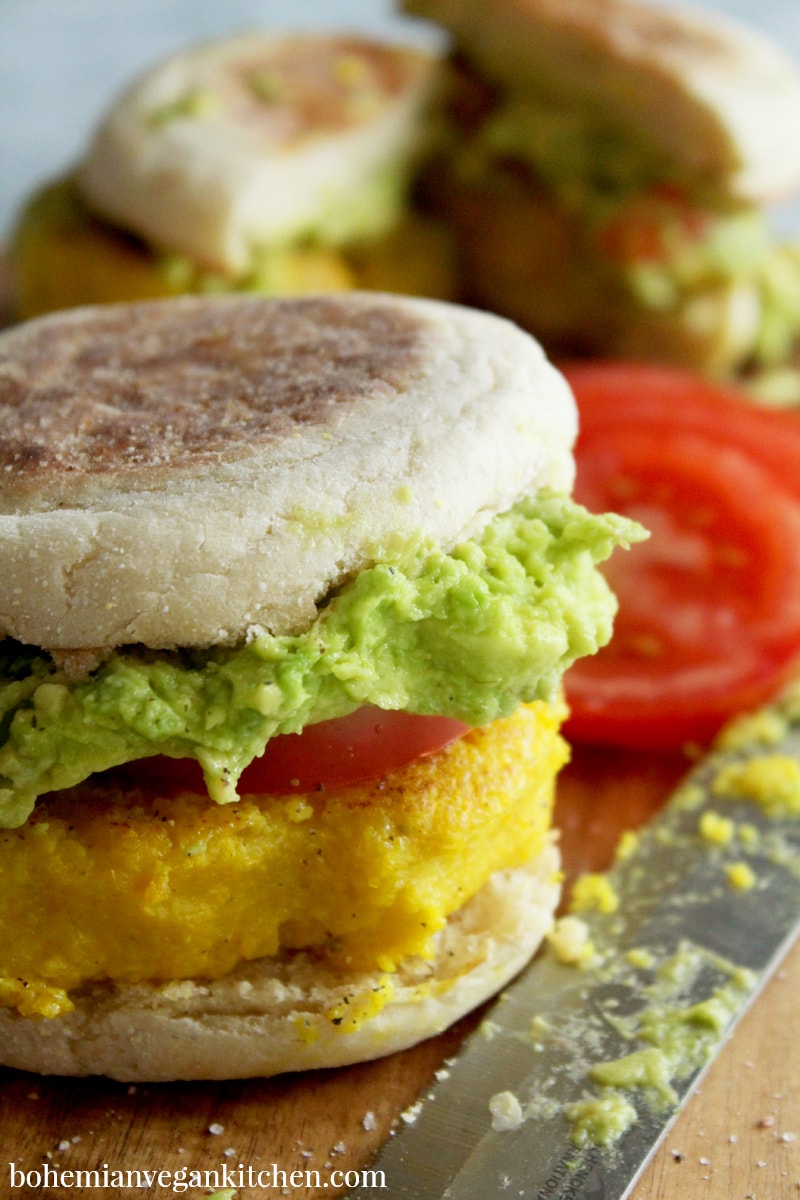 For a delicious (yet simple) breakfast, enjoy these vegan egg sandwiches, which are topped with juicy tomato sliced and smashed avocado! Completely vegan and soy-free, these breakfast sandwiches can be made gluten-free by using GF english muffins. #veganeggsandwich #veganeggsandwichbreakfast #veganeggrecipes #veganeggbreakfastsandwich #veganegg #bohemianvegankitchen