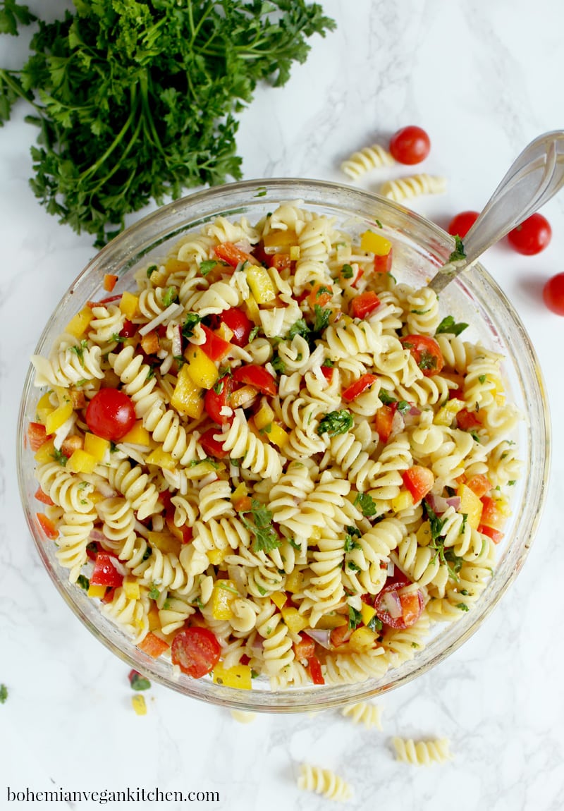 Be prepared for the week ahead with this simple + flavorful vegan pasta salad! Easy to pull together, this pasta salad can be made from start to finish in 20 minutes, leaving you more time to relax before you start your workweek. #veganpastasalad #veganpastasaladrecipes #veganpastasaladitalian #veganpastasaladeasy #bohemianvegankitchen