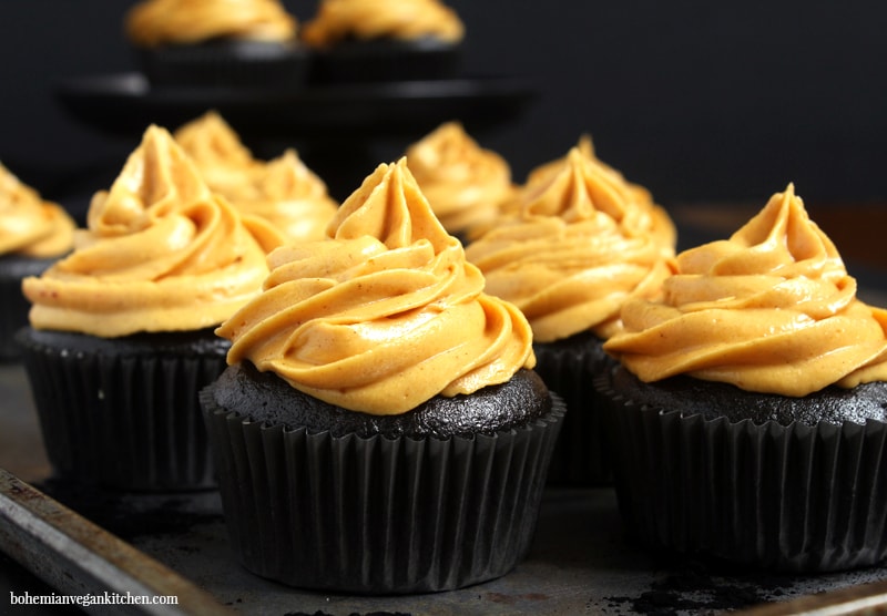 Make Halloween wicked delicious with these black chocolate coffee flavored cupcakes, topped with vibrant pumpkin pie frosting. These vegan Halloween cupcakes are easy to make, but result in a stunning finish that will put a spell on anyone who tastes them! #veganhalloweencupcakes #veganhalloweenrecipes #veganhalloweentreats #blackdesserts #veganhalloweendesserts #veganhalloweenfood #bohemianvegankitchen