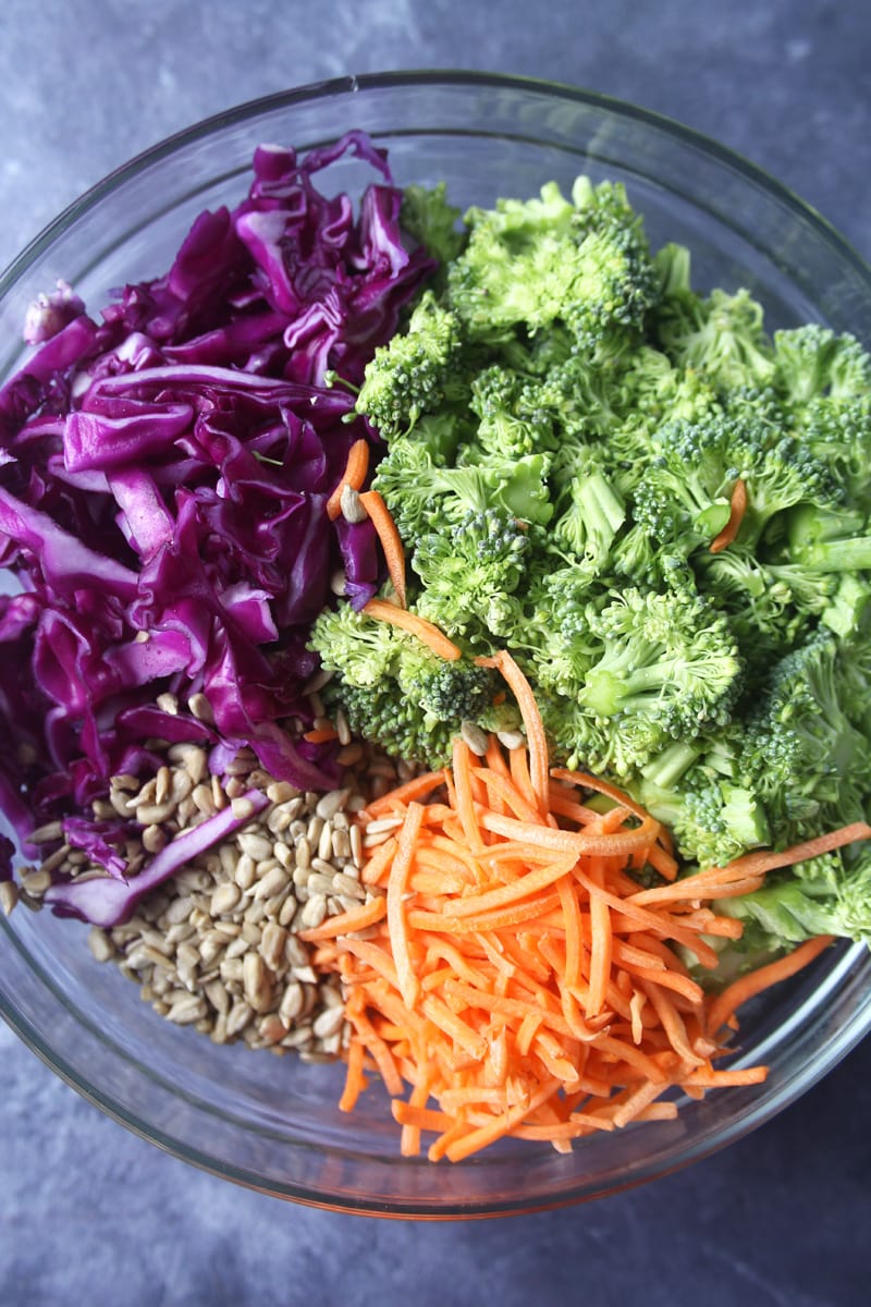 medium bowl with fresh vegetables layered for this healthy broccoli salad