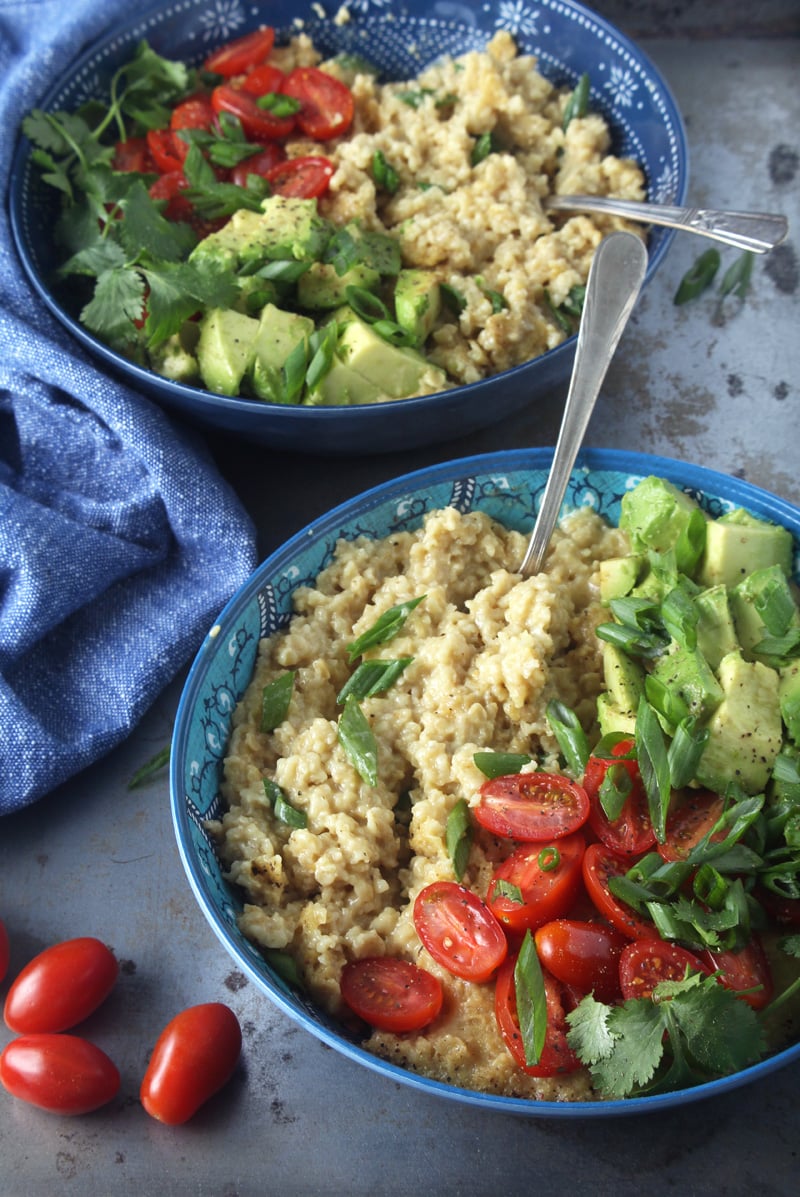 Who says oatmeal has to be sweet? I LOVE making this cheesy + savory vegan oatmeal, which takes less than 10 minutes to make! Topped with fresh tomatoes, diced avocado, cilantro, and green onions, this easy breakfast is the perfect way for your family to start the day. #veganbreakfastrecipes #veganbreakfasthealthy #veganbreakfastideas #quickveganbreakfast #veganoatmealrecipes #veganoatmealsavory #bohemianvegankitchen 