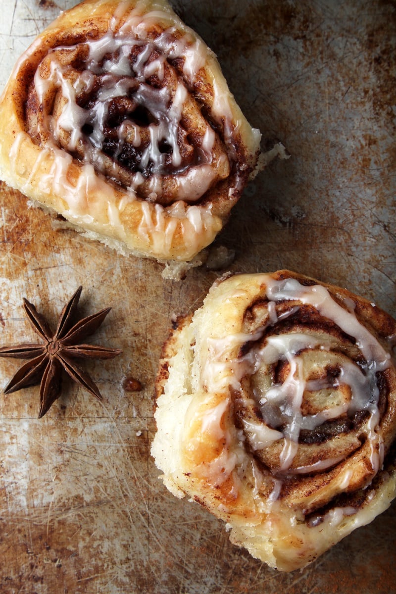 Two cinnamon rolls with star anise. 