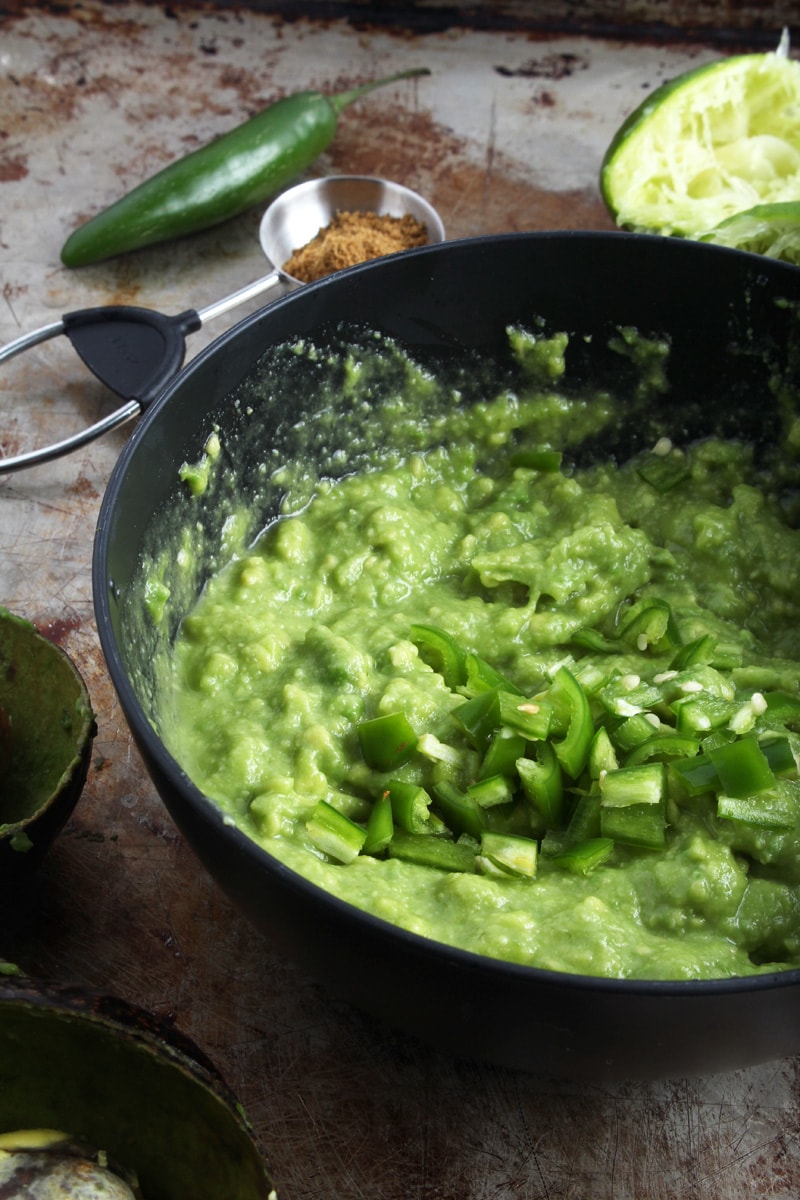 Picture of a bowl of guacamole being made.