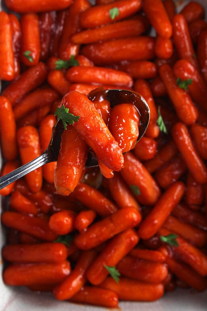 close up of instant pot carrots on a spoon, ready to eat