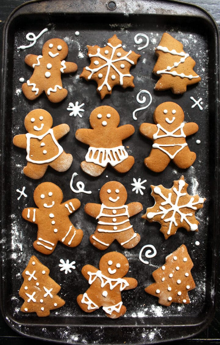 overhead picture of vegan gingerbread cookies, including men, Christmas trees, and snowflakes.