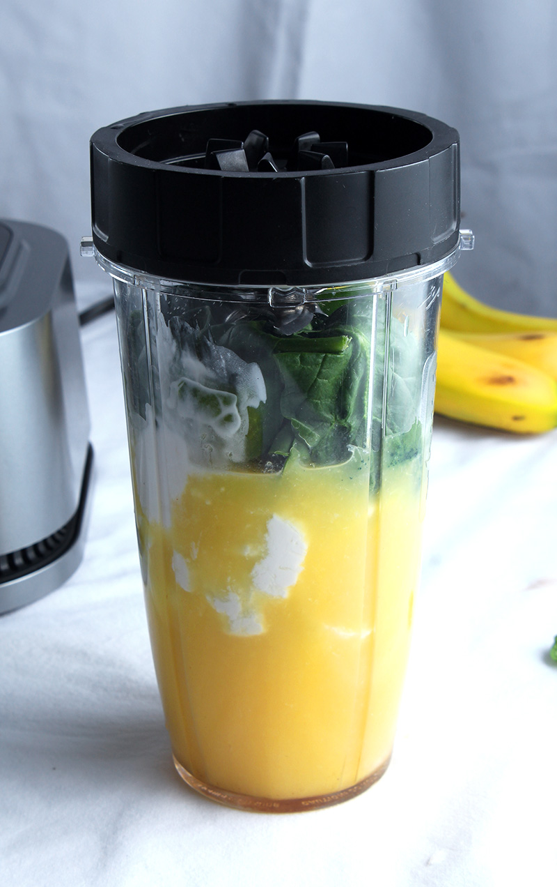 all the ingredients for green orange smoothie in a single serving blender cup, pre blended 